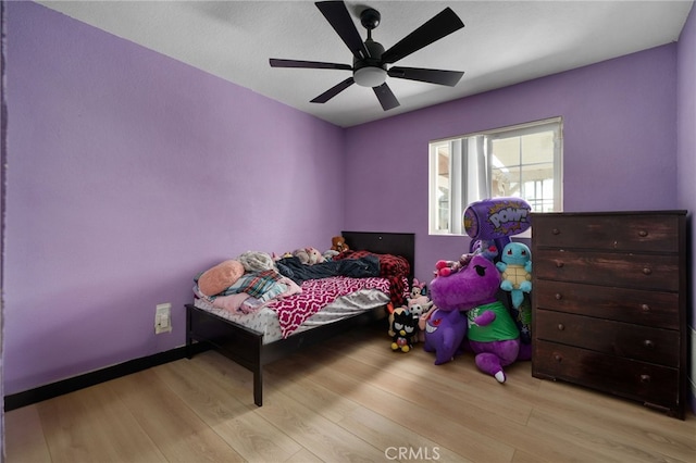 bedroom featuring ceiling fan, baseboards, and wood finished floors