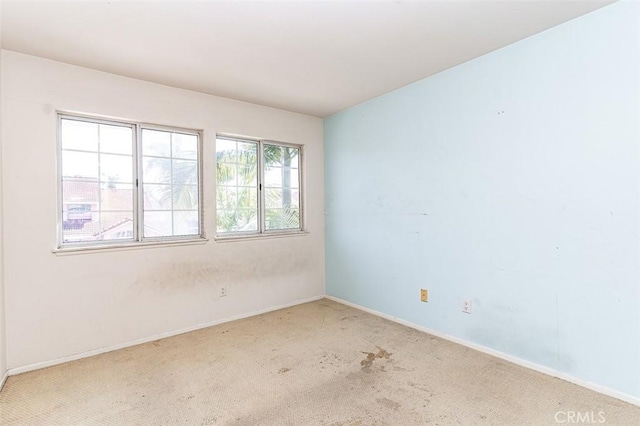 unfurnished room with baseboards and carpet floors