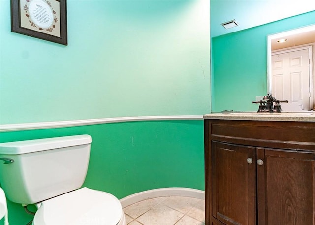 half bath featuring tile patterned floors, visible vents, toilet, baseboards, and vanity