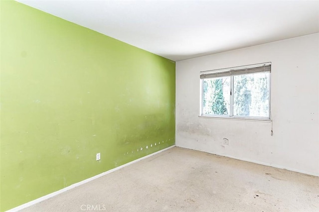 carpeted spare room with baseboards