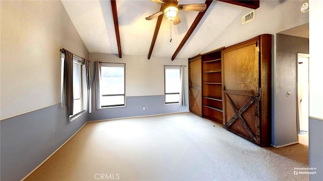 spare room with visible vents, light colored carpet, vaulted ceiling with beams, and ceiling fan