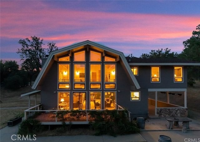 back of property at dusk featuring a patio