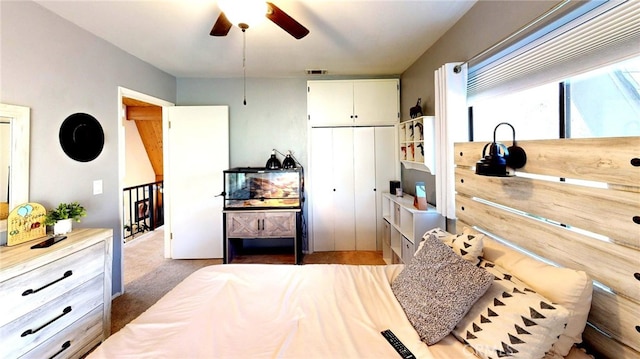 carpeted bedroom featuring a closet, visible vents, and a ceiling fan