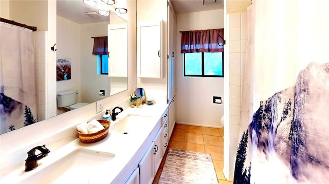 bathroom featuring tile patterned floors, toilet, and a sink