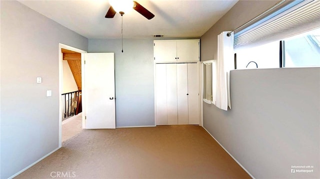 unfurnished bedroom featuring a closet, visible vents, carpet flooring, and ceiling fan