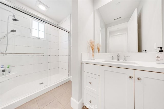 bathroom featuring tile patterned flooring, visible vents, a stall shower, and vanity