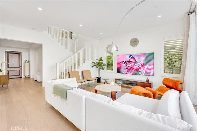 living area with recessed lighting, stairs, and light wood-style floors