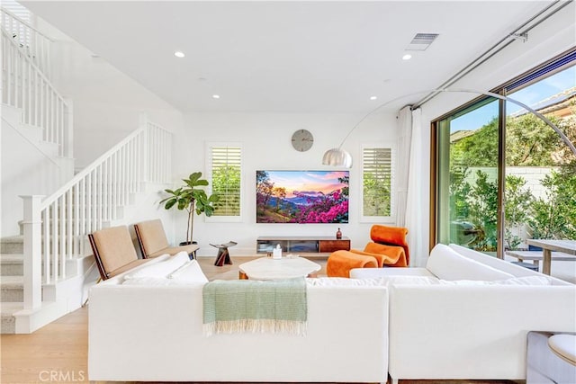 living room featuring recessed lighting, a healthy amount of sunlight, visible vents, and light wood finished floors