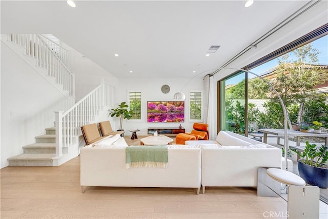 living room with stairway, recessed lighting, visible vents, and light wood-type flooring