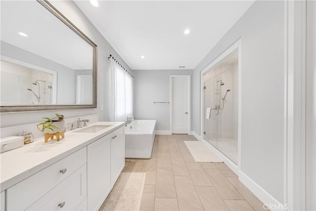 full bath with a shower stall, baseboards, recessed lighting, a freestanding tub, and vanity