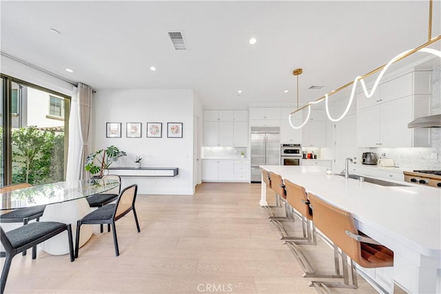 kitchen featuring tasteful backsplash, visible vents, appliances with stainless steel finishes, and a sink