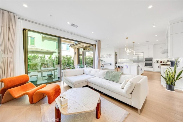 living room featuring visible vents, recessed lighting, and light wood-type flooring