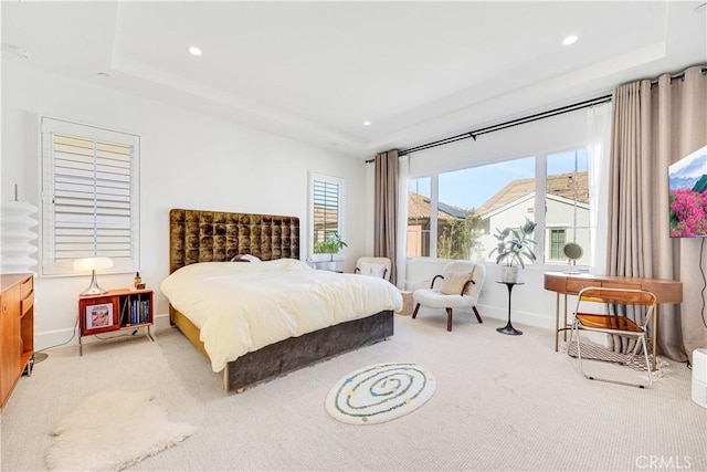 bedroom with a raised ceiling, recessed lighting, and carpet floors