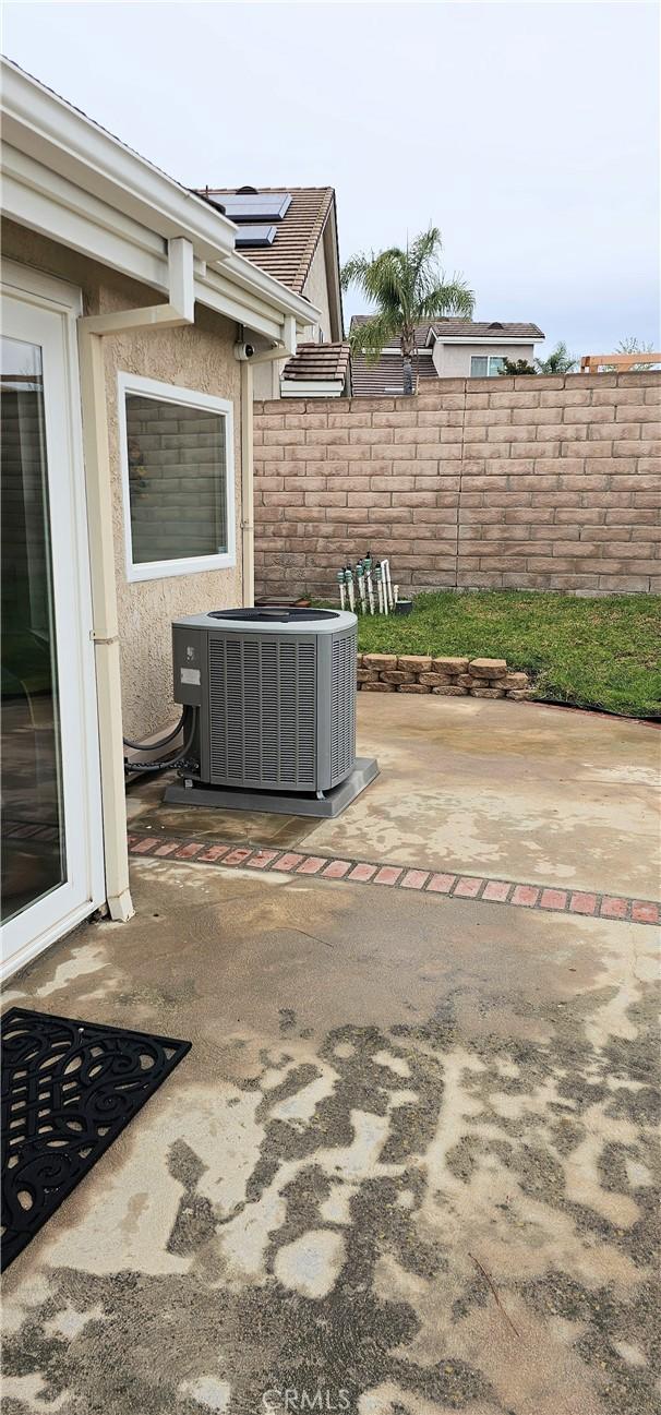 view of patio with central AC and fence