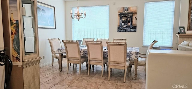 dining room with tile patterned flooring, a notable chandelier, and baseboards