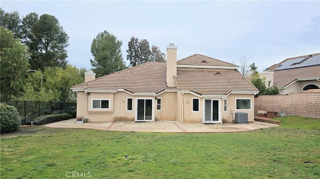 rear view of house featuring a yard, central air condition unit, a fenced backyard, and a chimney