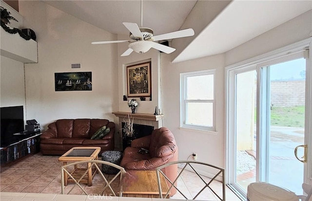 living area featuring ceiling fan, visible vents, light tile patterned flooring, and vaulted ceiling