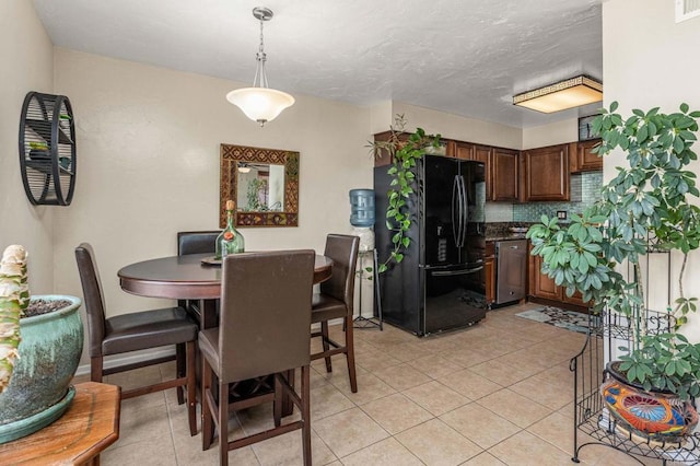 dining space with light tile patterned floors, baseboards, and a textured ceiling