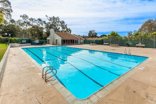 community pool featuring a patio and fence