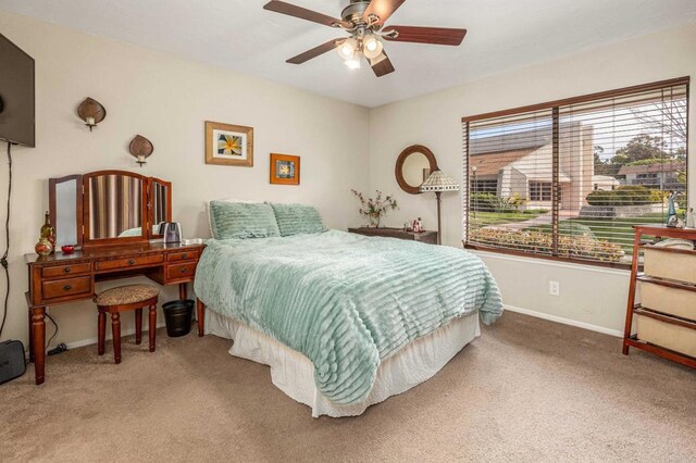 carpeted bedroom featuring baseboards and ceiling fan