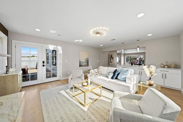 living room with recessed lighting, french doors, light wood-style floors, and visible vents