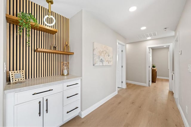 corridor with recessed lighting, visible vents, light wood-style flooring, and baseboards