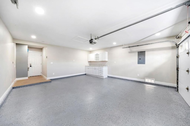 garage featuring recessed lighting, electric panel, a garage door opener, and baseboards