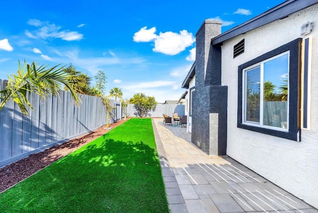 view of yard with a fenced backyard and a patio