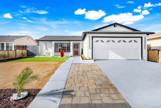 ranch-style home with concrete driveway, fence, a garage, and stucco siding