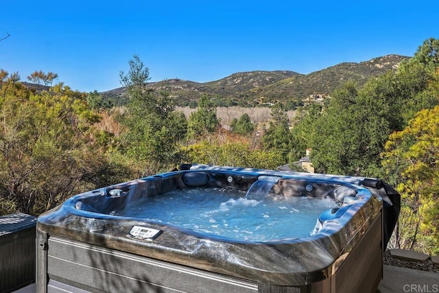 view of pool featuring a mountain view and a hot tub