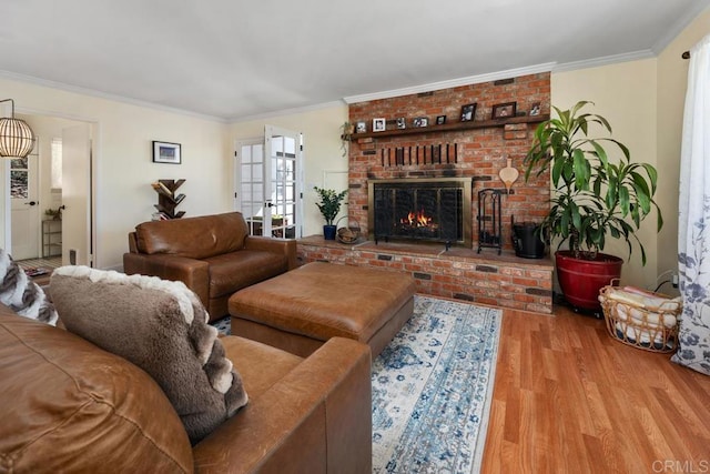 living area featuring wood finished floors, a brick fireplace, and ornamental molding