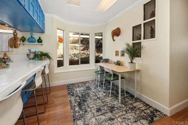 home office featuring wood finished floors, baseboards, and ornamental molding