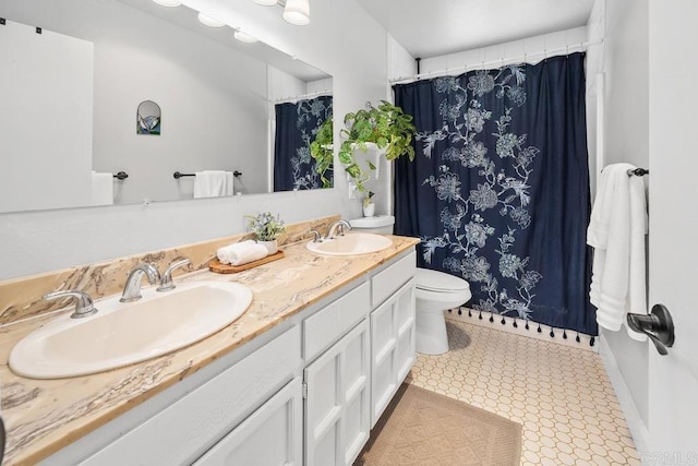 bathroom with a sink, curtained shower, toilet, and double vanity