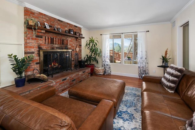 living area featuring visible vents, ornamental molding, wood finished floors, baseboards, and a brick fireplace