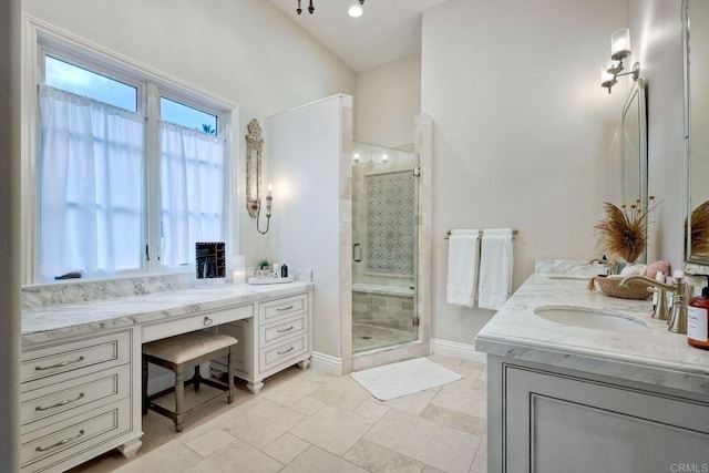 full bath with stone tile flooring, a stall shower, two vanities, and a sink