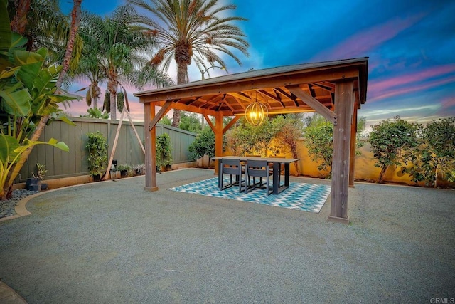 patio terrace at dusk featuring a gazebo and a fenced backyard