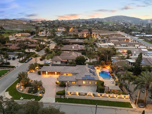 aerial view at dusk featuring a residential view and a mountain view