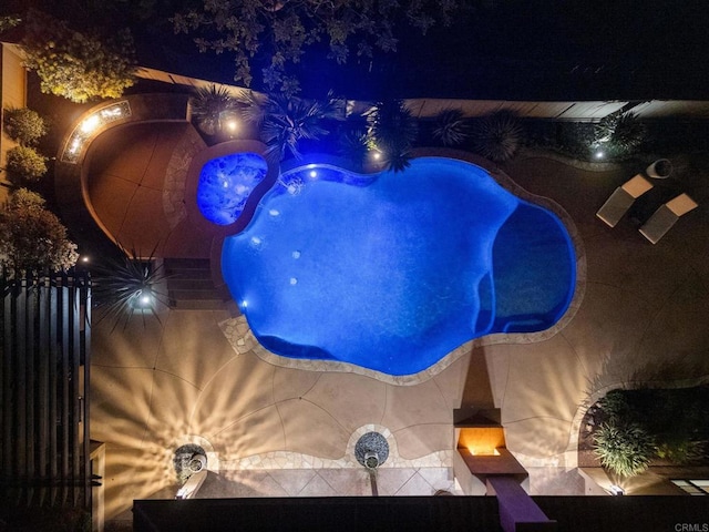 pool at night featuring fence