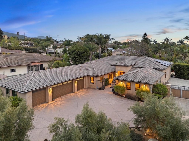 view of front of house featuring fence, stucco siding, concrete driveway, an attached garage, and a tile roof