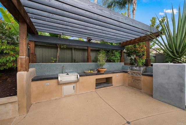 view of patio / terrace featuring a sink, grilling area, exterior kitchen, and a pergola