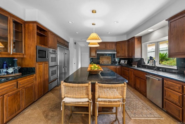 kitchen with decorative light fixtures, a sink, under cabinet range hood, stainless steel appliances, and recessed lighting