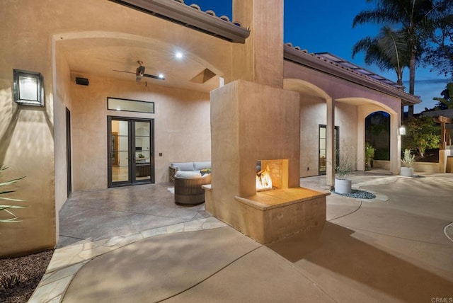 view of patio / terrace featuring a multi sided fireplace and french doors