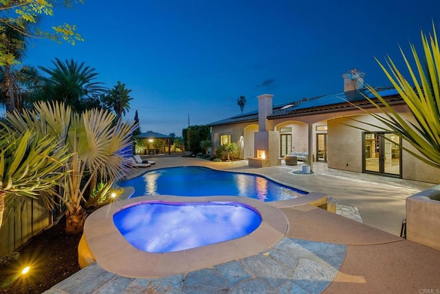 outdoor pool with a patio, an in ground hot tub, and french doors