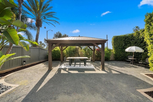 view of patio / terrace featuring a fenced backyard, outdoor dining space, and a gazebo