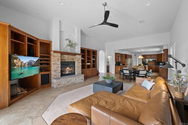 living room featuring visible vents, built in features, ceiling fan, and a fireplace