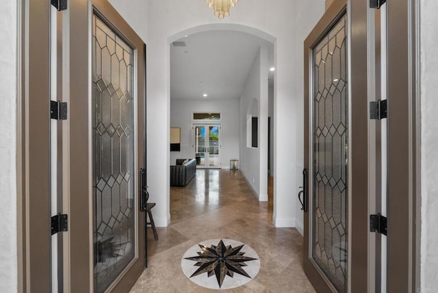 entrance foyer featuring baseboards, arched walkways, recessed lighting, and french doors