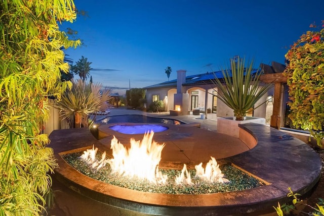 outdoor pool featuring an outdoor fire pit