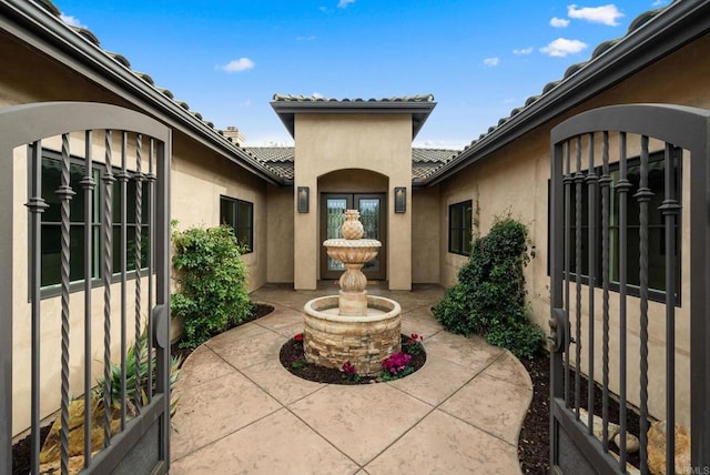 view of exterior entry featuring a tile roof and stucco siding