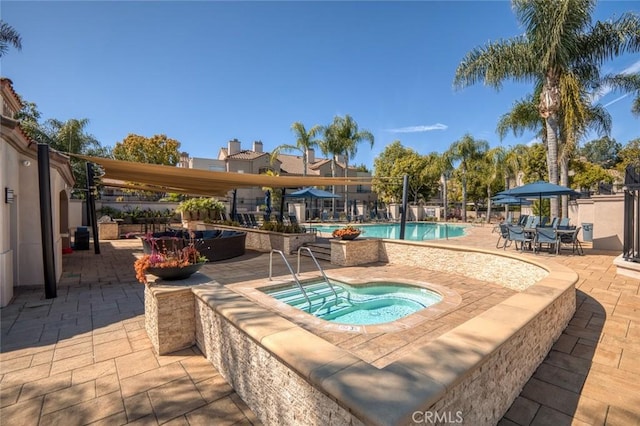 community pool with a patio and a community hot tub