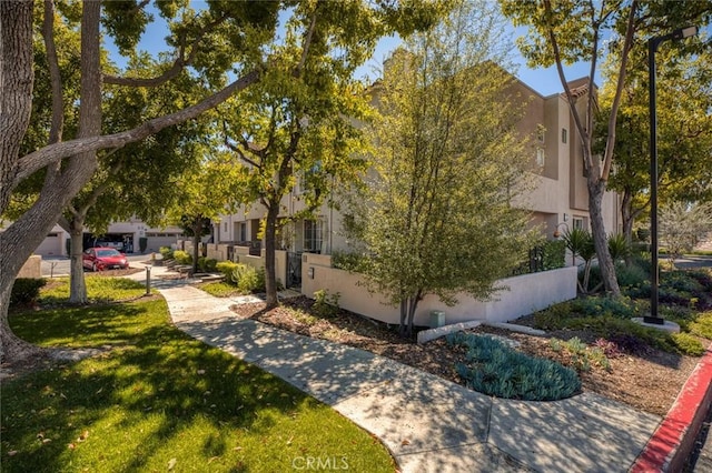 view of home's community featuring a lawn and fence